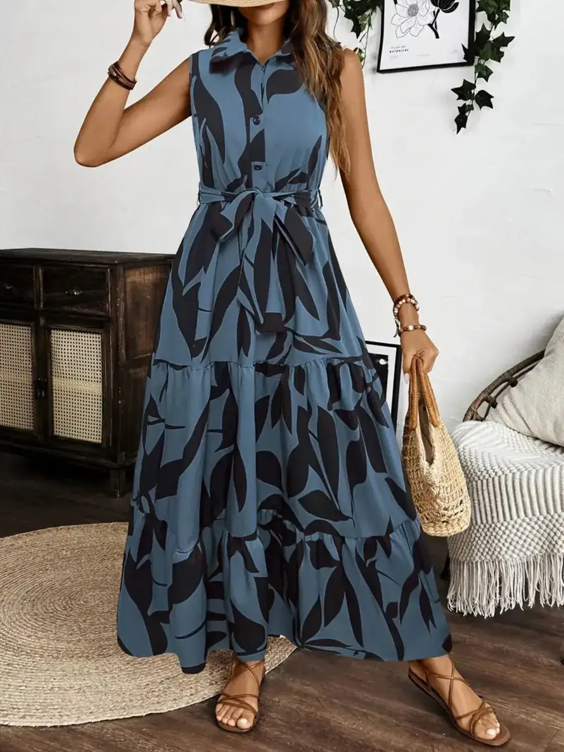 Sleeveless maxi dress with buttoned front and tie waist, featuring a leafy print, ideal for casual summer outings.