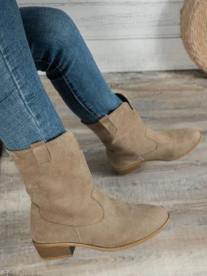 Western style block heel boots in light tan suede, worn with blue jeans, showcasing a low heel design for comfort.