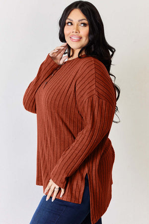 Model wearing a rust-colored ribbed high-low T-shirt with side slits and long sleeves.