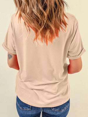 Back view of a woman wearing a beige t-shirt with rolled sleeves, showcasing her hair and tattoo.