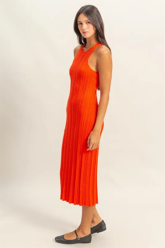 Woman in an orange ribbed knit dress, showcasing a bodycon silhouette and elegant style, perfect for versatile occasions.