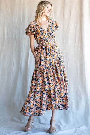 Model wearing Cotton Bleu Floral Ruffled Midi Dress with vibrant floral patterns and stylish ruffles.