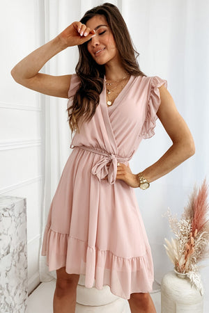 Full size ruffled surplice cap sleeve dress in soft pink, featuring a tie waist and tiered hem detail.