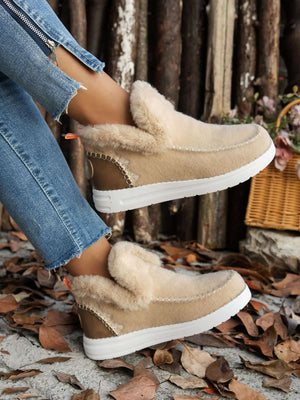 Furry suede round toe flat sneakers with faux fur soles, styled with casual denim jeans against a natural backdrop.