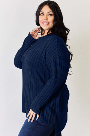 Curvy model wearing navy Basic Bae ribbed half button long sleeve high-low T-shirt, showcasing side slit detail.