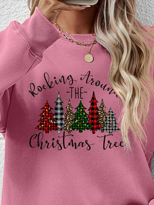 Pink sweatshirt with 'Rocking Around the Christmas Tree' graphic and colorful trees design.