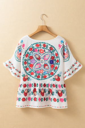 Floral print round neck blouse with ruffle trim, features vibrant embroidery and short sleeves, perfect for casual wear.