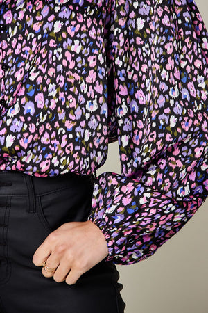 Close-up of a vibrant floral printed long sleeve blouse featuring frill sheer fabric and billowy sleeves.