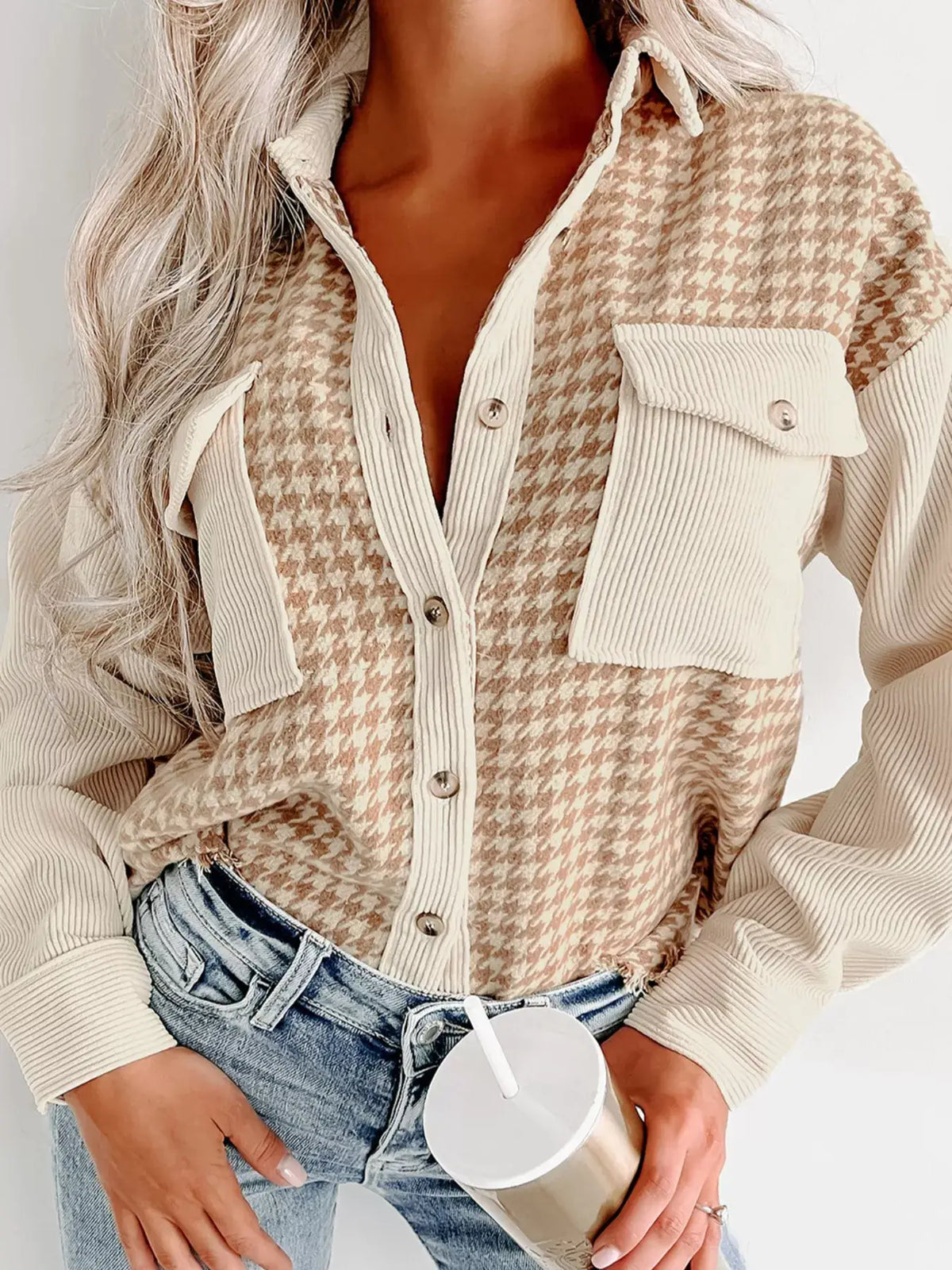 Houndstooth Button-Down Jacket worn by a model with a drink, featuring button-up design and pocketed details.