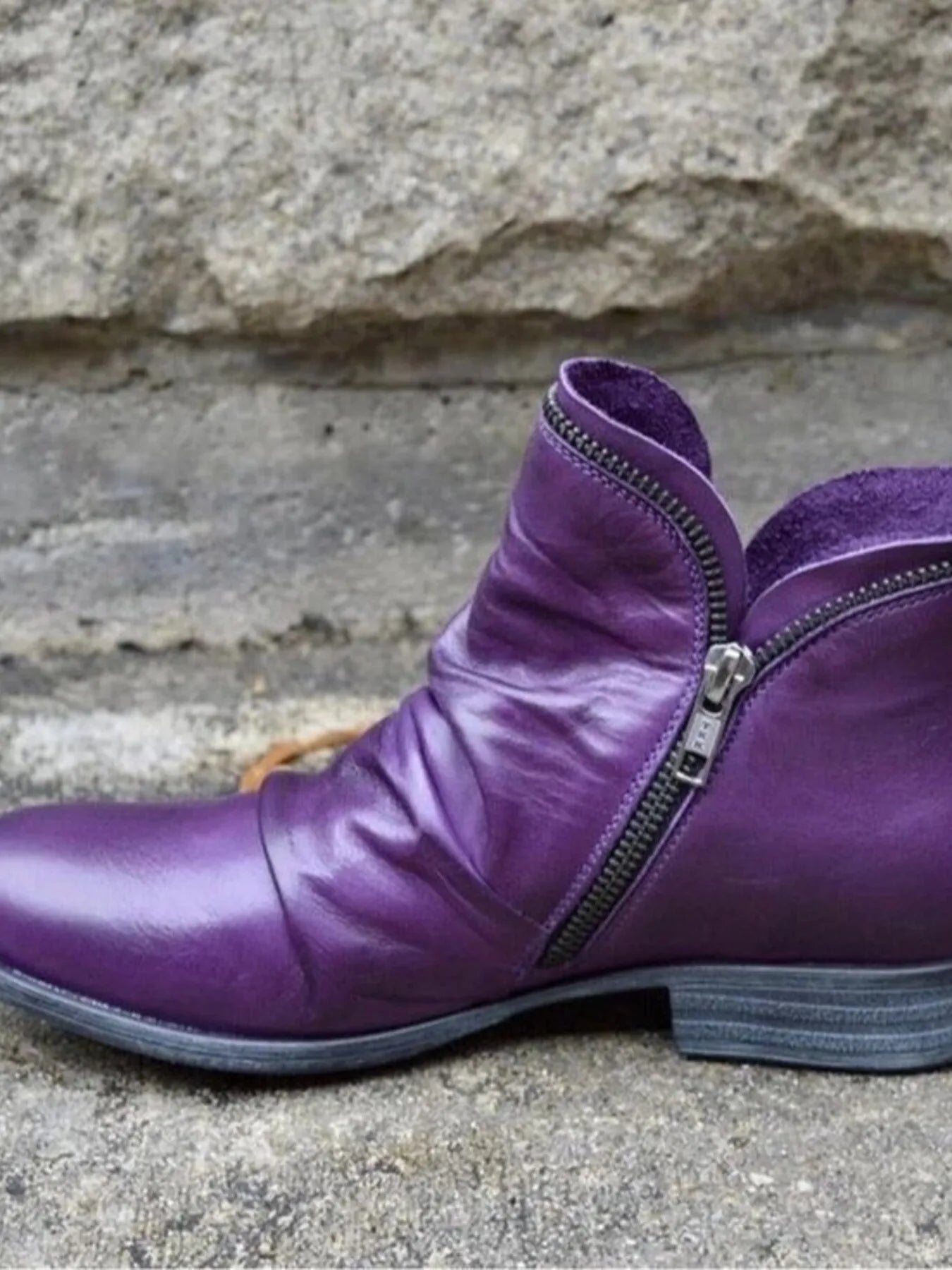 Stylish purple leather boots featuring a zip closure and a comfortable low heel.