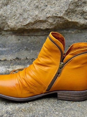 Stylish yellow round toe block heels boots with zipper detail for a trendy look.