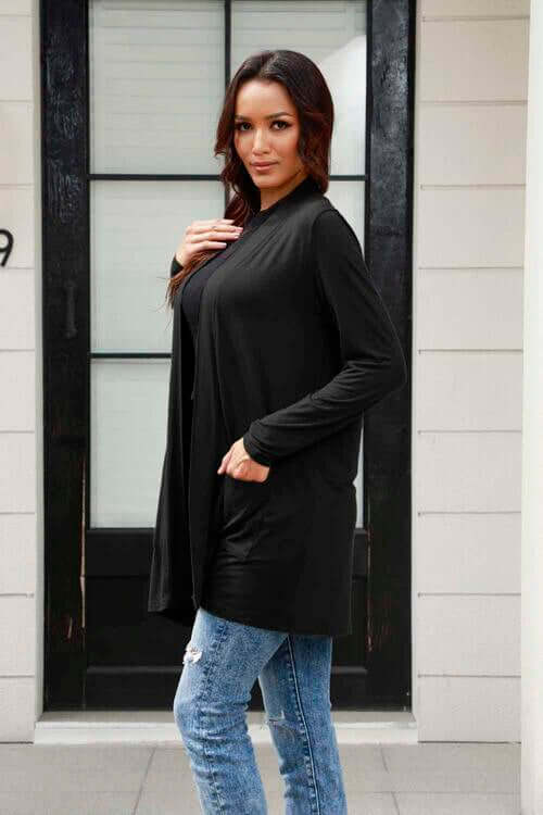 Model wearing a black Basic Bae long sleeve cardigan with pockets, styled with jeans.