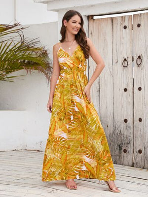 Model wearing a Printed Surplice Spaghetti Strap Dress with tropical leaf patterns, perfect for summer outings.