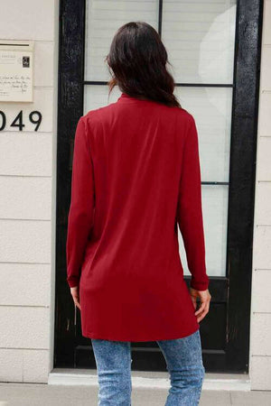 Back view of a woman wearing a long sleeve red cardigan, showcasing its stylish design and relaxed fit.