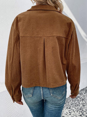 Back view of a collared neck button front jacket in brown with pockets, paired with casual jeans.