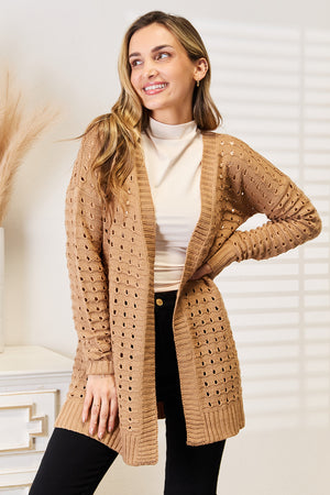 Woman modeling a beige openwork ribbed open front cardigan, showcasing its elegant design and layering versatility.