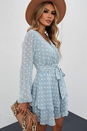 Tied layered polka dot balloon sleeve dress in light blue, styled with a hat and handbag, perfect for casual occasions.