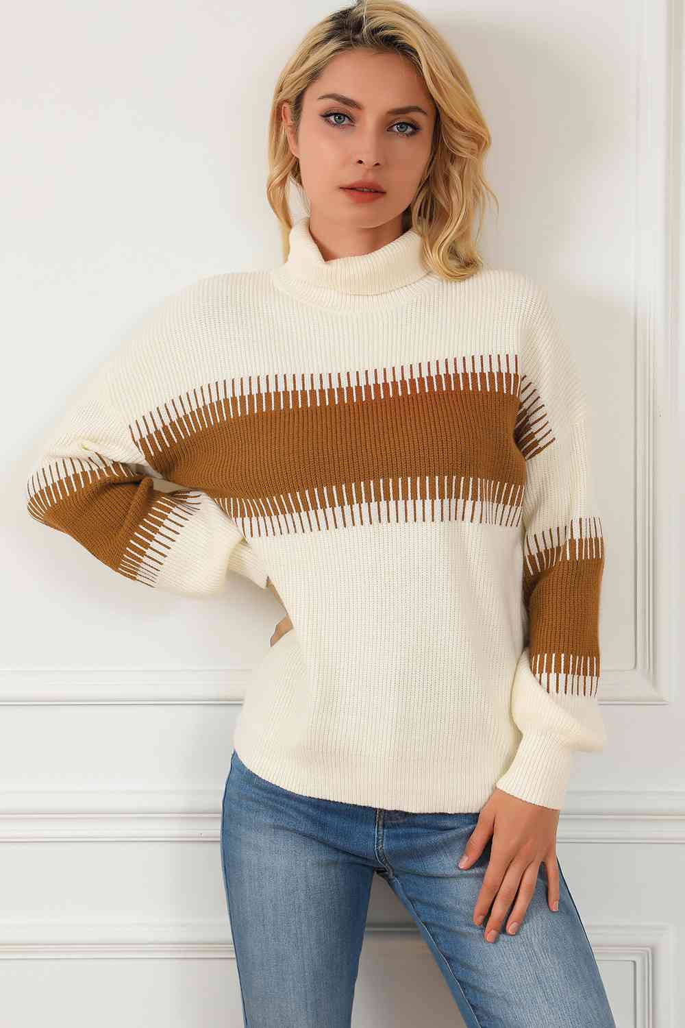 Model wearing a contrast turtleneck long sleeve sweater with brown and cream stripes, paired with denim jeans.