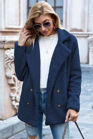 Model wearing a navy blue lapel collar sherpa coat, featuring double-breasted design and casual style.