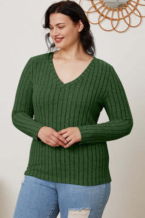 Model wearing a green ribbed V-neck long sleeve t-shirt paired with jeans, showcasing a basic and stylish look.