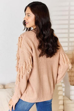 Stylish long sleeve sweater with tassel details, featuring a relaxed fit and bohemian flair, perfect for any occasion.