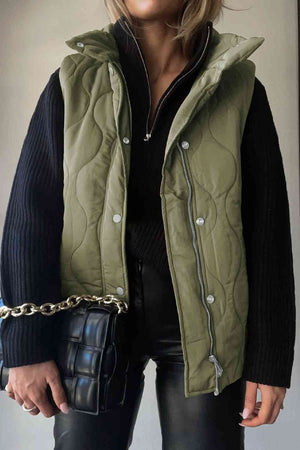 Stylish collared neck vest in olive green with pockets, paired with a black sweater and chic handbag.