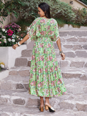 Back view of a woman in a floral V-neck short sleeve dress, styled with a flowy silhouette, walking down stone steps.