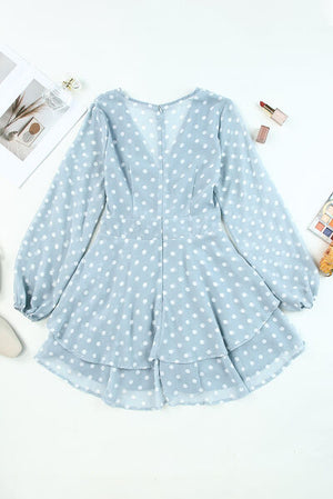Back view of a light blue polka dot balloon sleeve dress with a tiered skirt and sheer fabric.