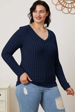Plus size navy ribbed V-neck long sleeve t-shirt styled with jeans, perfect for casual wear.
