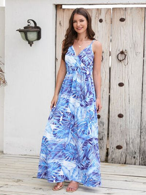 Model wearing a Printed Surplice Spaghetti Strap Dress with a blue leaf pattern, perfect for summer occasions.