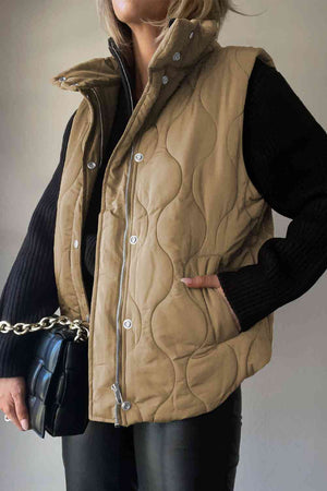 Collared neck vest in tan with pockets, quilted design, paired with a black sweater and handbag.