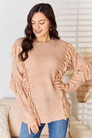 Stylish long sleeve sweater with tassel accents in soft pink, perfect for casual or dressed-up occasions.