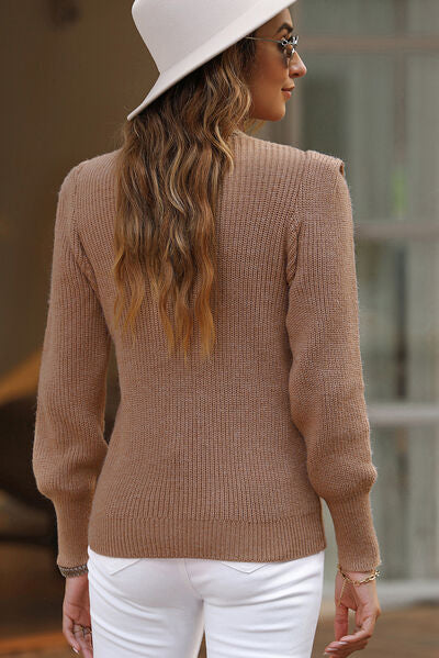 Notched long sleeve sweater in tan color, featuring textured fabric and stylish design, paired with a hat and sunglasses.