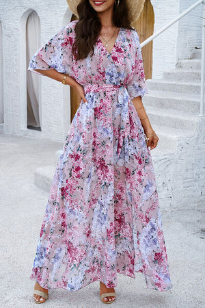 Model wearing a printed tied half sleeve slit dress in a floral pattern, perfect for summer outings.