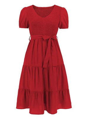 Red smocked tie front short sleeve tiered dress with a flattering silhouette and comfortable fit.
