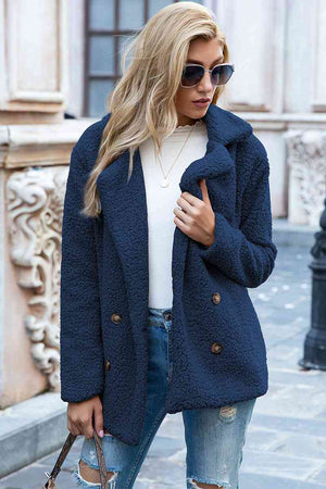 Woman wearing a navy blue full-size lapel collar sherpa coat, casual style with double-breasted buttons, sunglasses on.