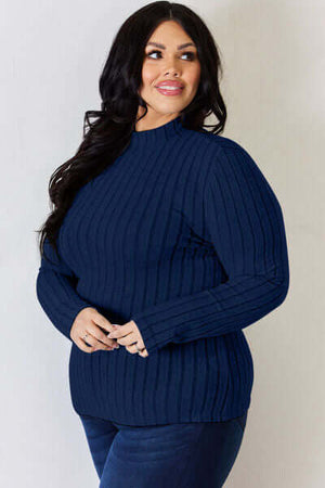 Plus size model in a navy ribbed mock neck long sleeve t-shirt, showcasing a comfortable basic style.