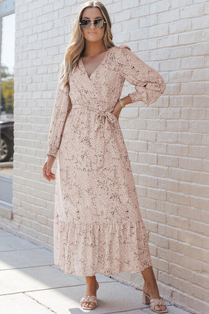 Model wearing a Printed Tie Front Ruffle Hem Dress in blush with sunglasses, standing against a brick wall.