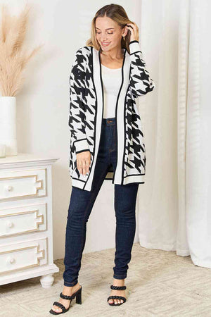Elegant woman in houndstooth open front longline cardigan styled with jeans, showcasing versatility and comfort.