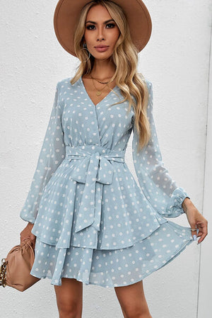 Tied layered polka dot balloon sleeve dress in blue with a stylish hat and handbag, perfect for summer outings.