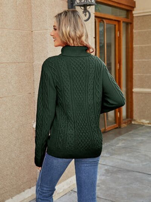 Back view of a woman wearing a green cable-knit mock neck sweater paired with jeans.