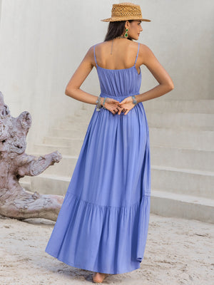 Model wearing a blue lace detail V-neck cami dress, showcasing its back design and flowy silhouette on a scenic backdrop.