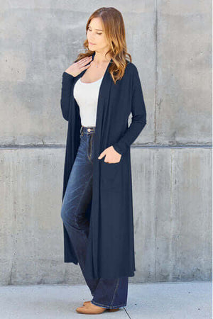 Model wearing Basic Bae full size open front long sleeve cover up in navy with pockets, styled with jeans.