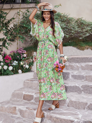 Smocked floral V-neck short sleeve dress showcased outdoors with flowers, perfect for summer occasions.