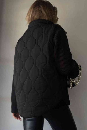 Back view of a collared black quilted vest, showcasing a stylish design and textures.