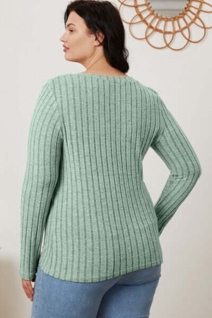 Plus-size model showcasing the back view of a ribbed mint green long sleeve top.