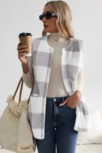 Model wearing a Sherpa plaid open front vest coat, styled with a turtleneck and jeans, holding a coffee cup.