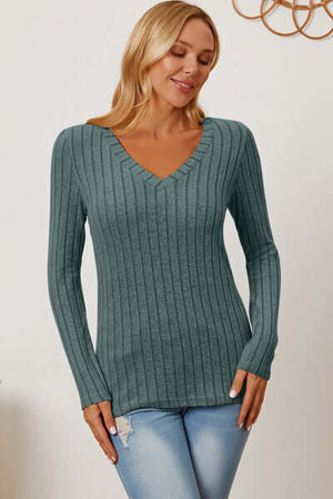 Model wearing a teal ribbed V-neck long sleeve t-shirt with slim fit style and slight stretch.