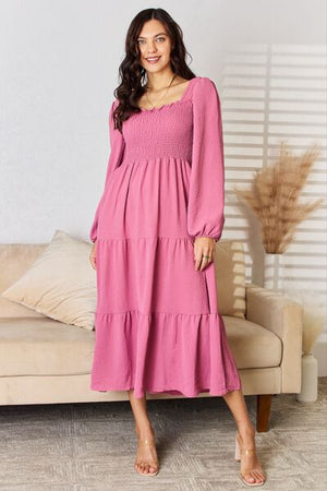Pink ruffle trim smocked tiered dress featuring a square neckline and long sleeves, perfect for casual or evening wear.