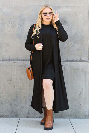 Model wearing Basic Bae black open front long sleeve cover up with sunglasses and stylish boots.